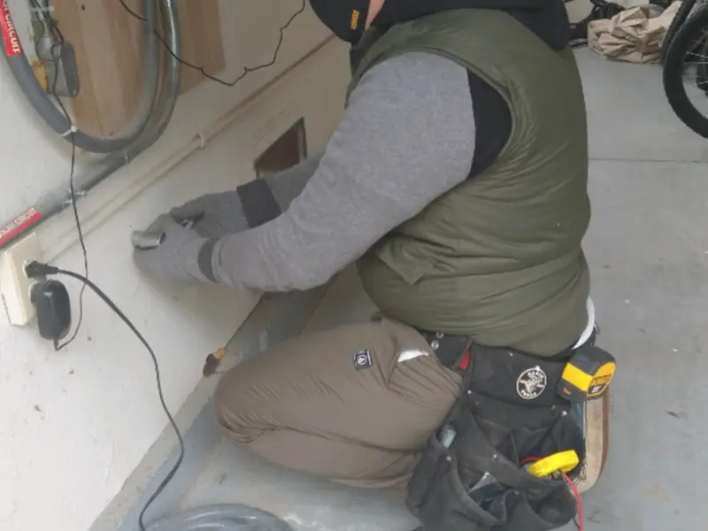 Electrician performing outlet wiring in a Watertown garage